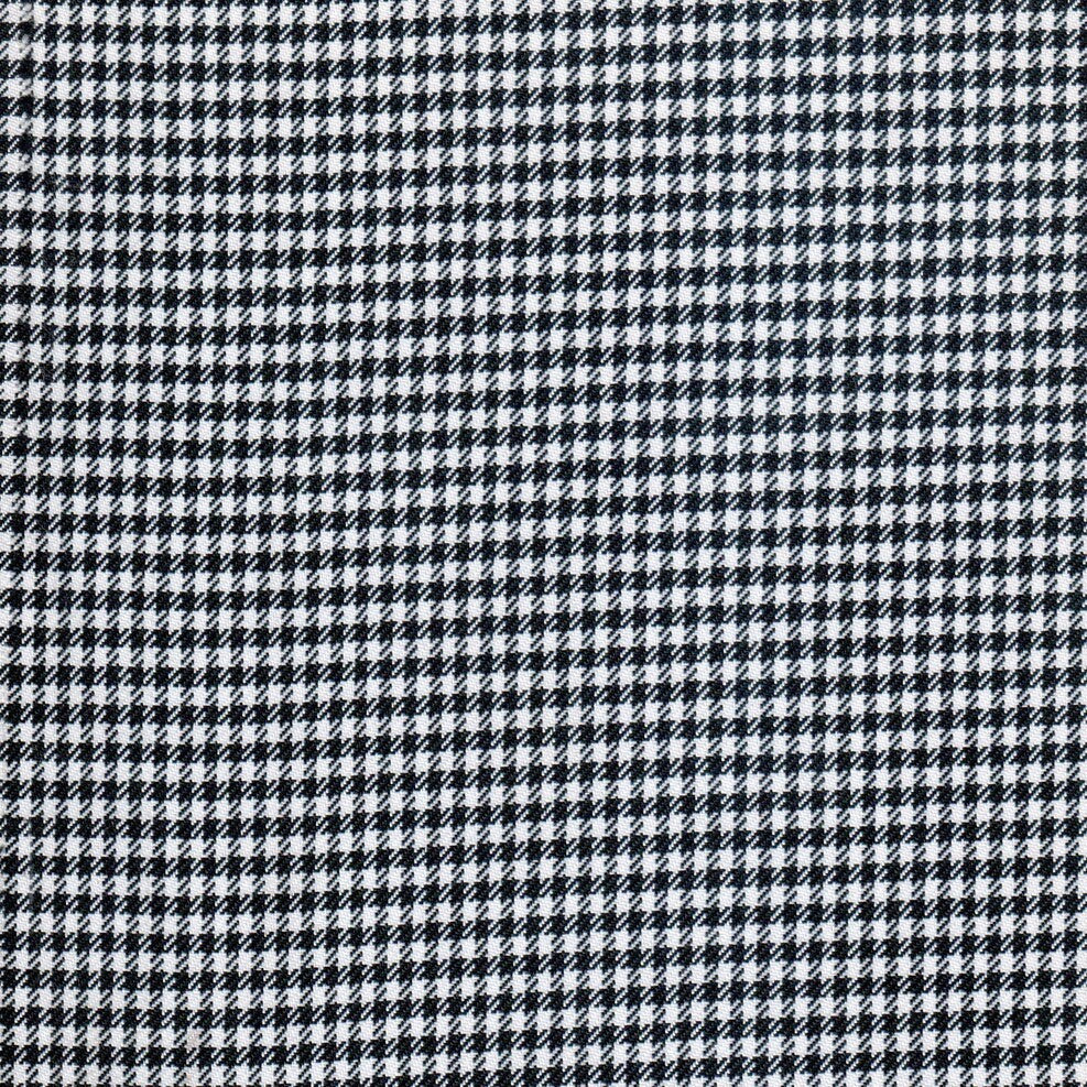 Tela gallineto diagonal SchoolLine en negro y blanco; diseño houndstooth diagonal, ideal para uniformes escolares e institucionales.